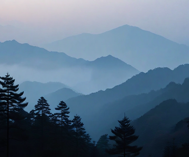 A misty Japanese mountain landscape at dusk with forested hills shrouded in fog, conveying a somber and serious atmosphere related to a criminal investigation